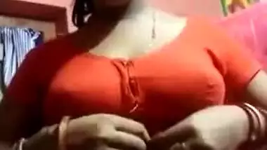 Aroused Desi wife slowly takes red top off to expose boobs for XXX fans